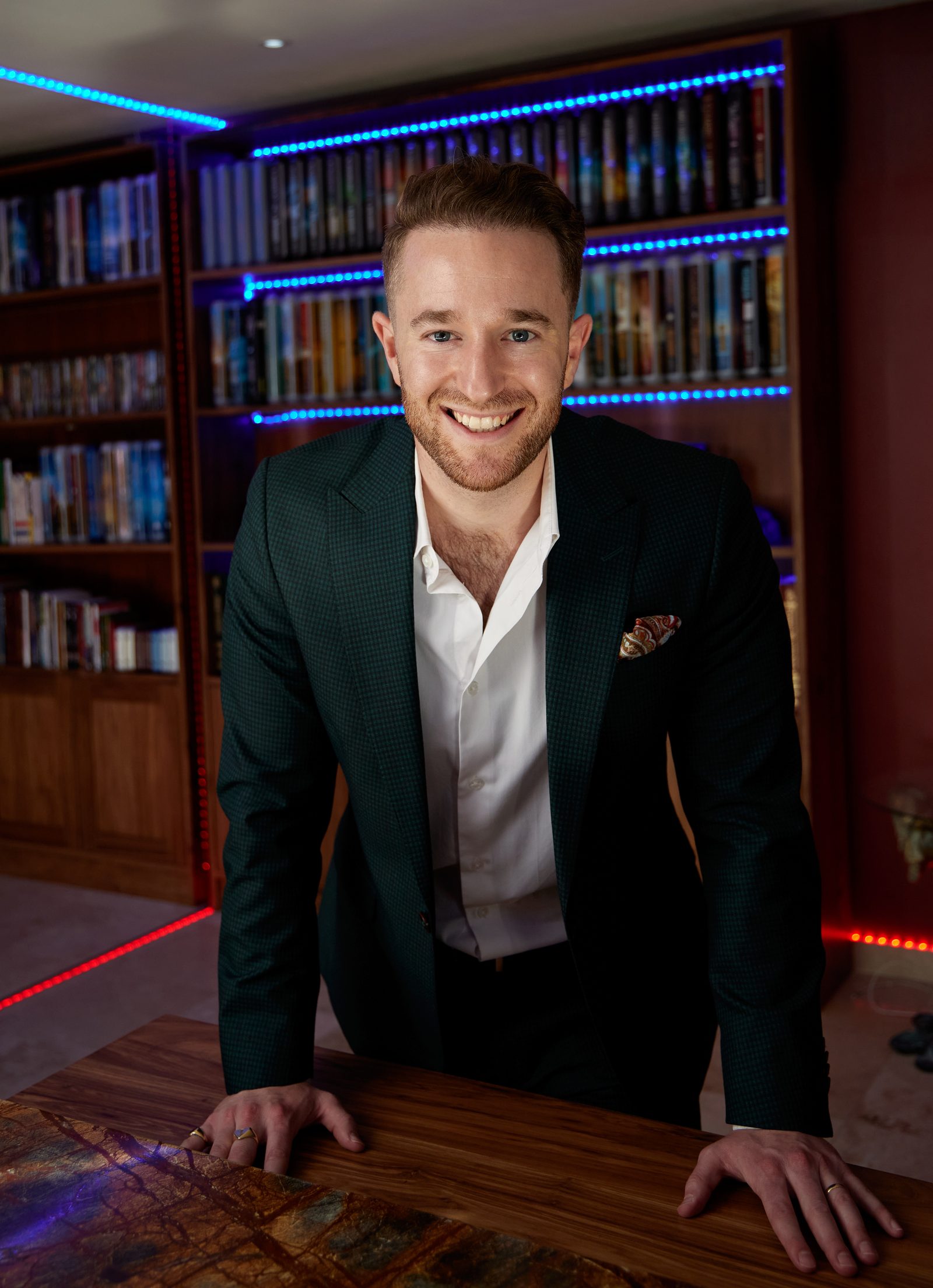 Gal Ezra — serial entrepreneur, international coach and marketing expert — leaning over a desk in his library, looking straight at you.