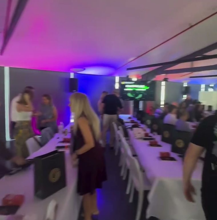 Attendees finding their seats in the purple-lit seminar room as day one begins