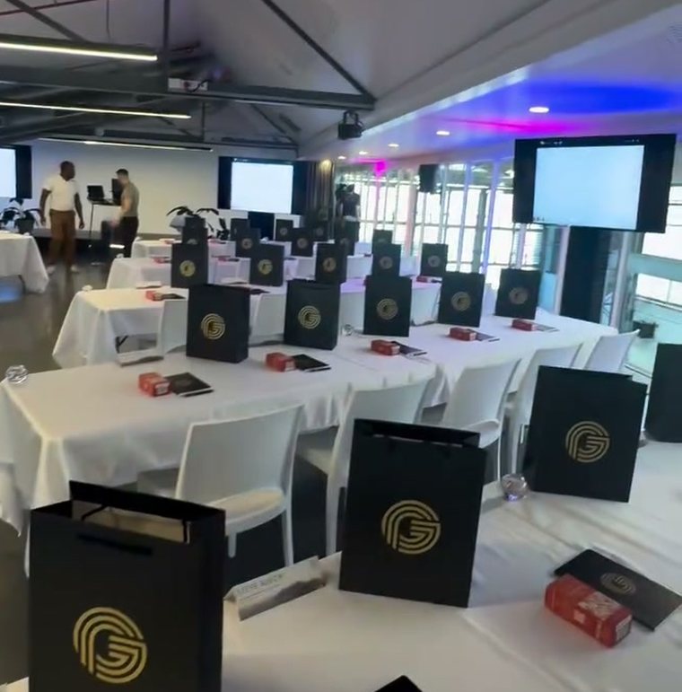 Seminar floor set for day one — white tables with Guaranteed Prosperity gift bags and workbooks