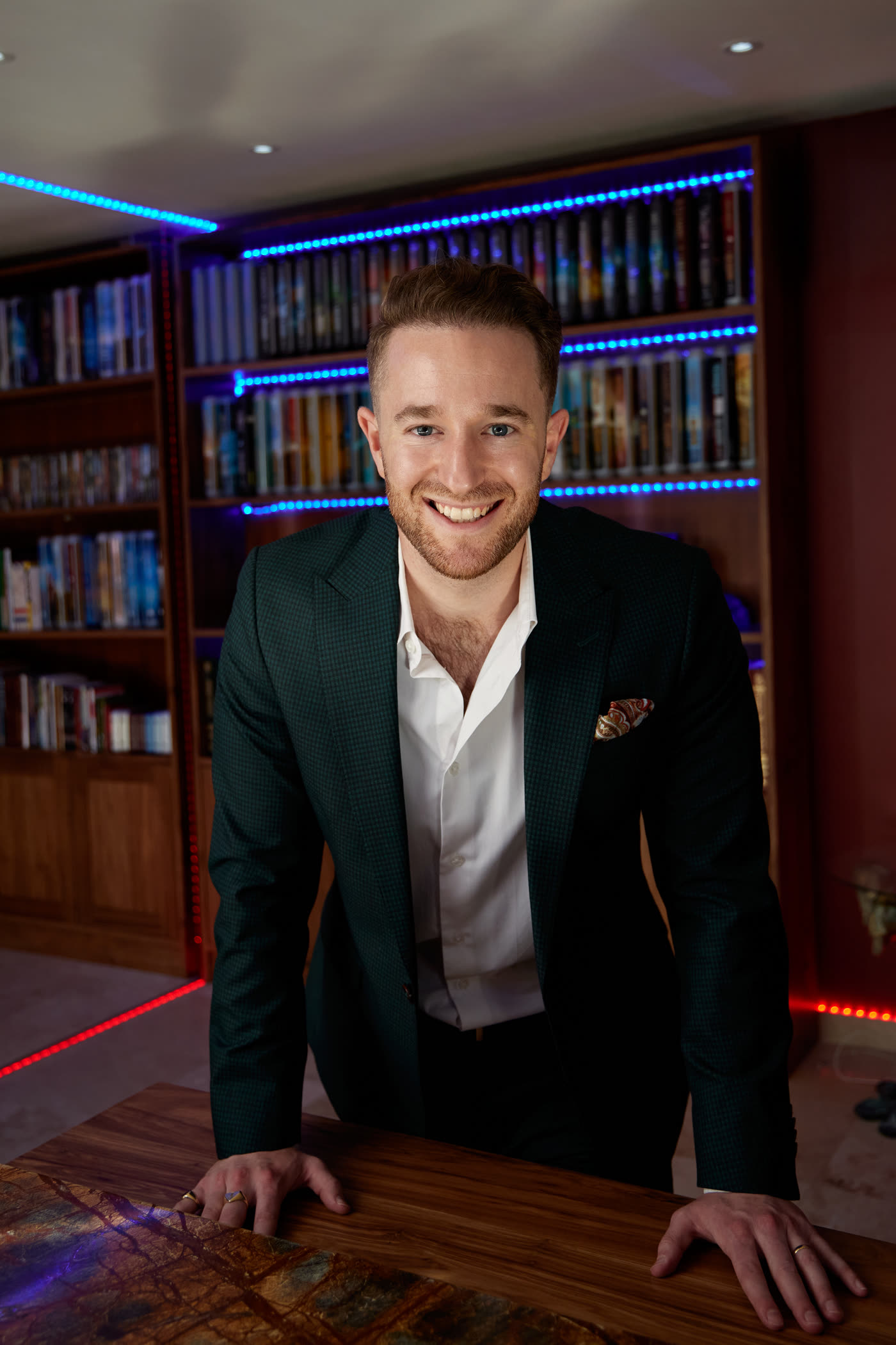 Gal Ezra smiling in his library — CEO of Guaranteed Prosperity